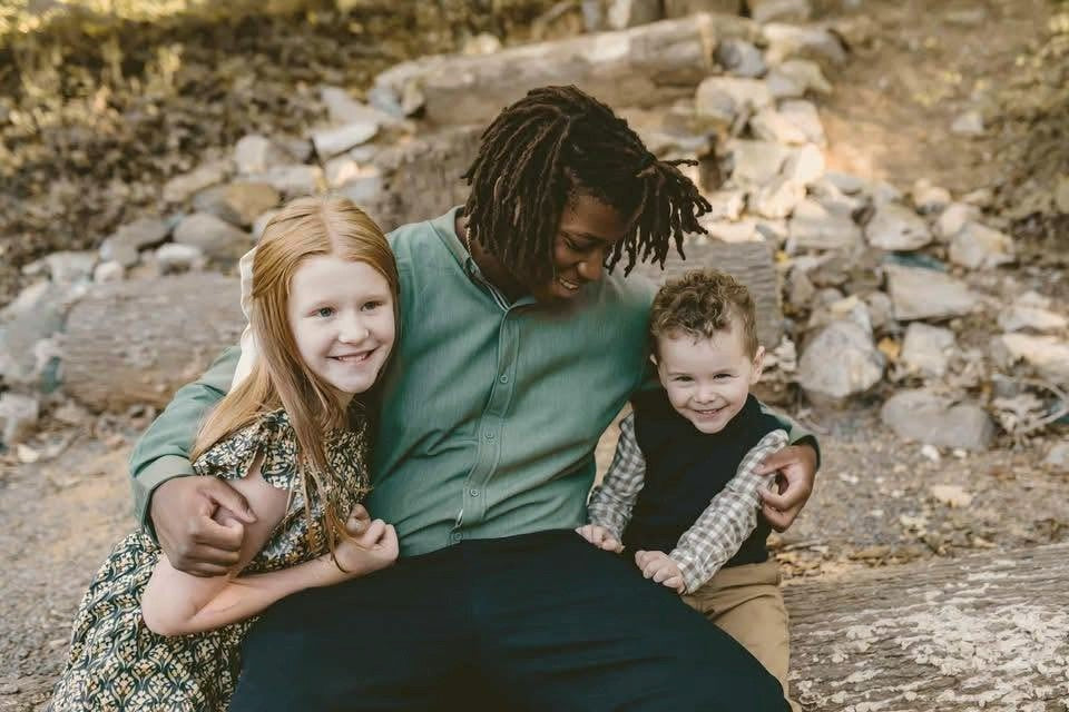 Christina's children sitting together outdoors, smiling