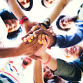 A circle of young people joining hands in the middle